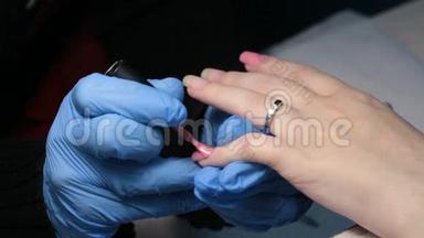 女人`修指甲。 在指甲上涂上粉红色指甲油